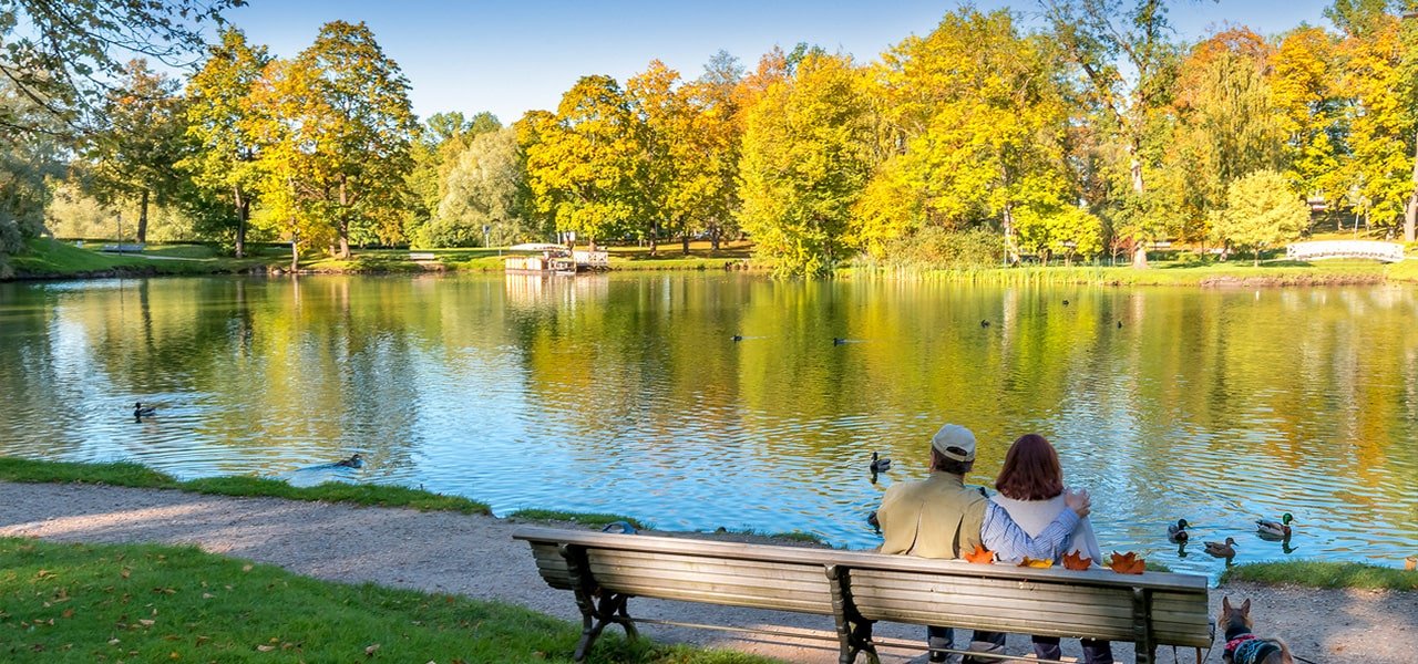 couple sitting on park bench in front of a lake at peachtree